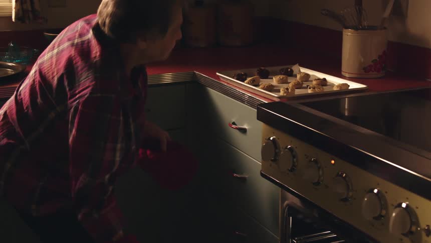 A woman is baking cookies in the kitchen