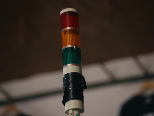 The green light of three sitting on stack above black tape blinks