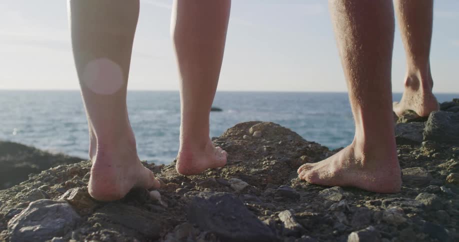 Two people are walking on the coast of a beach