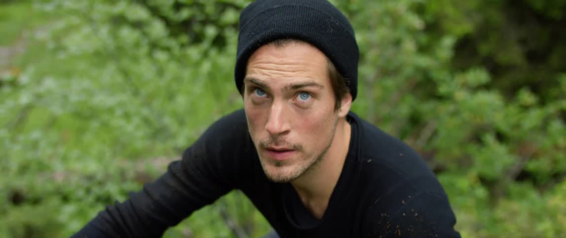 A man is standing in a wooded area in spring