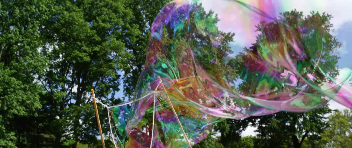Giant bubble wand with a long colorful shimmering bubble waving in the wind