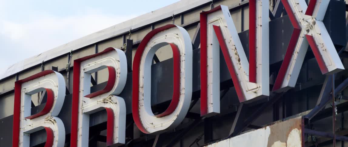Daytime view of a lighted metal sign with the word bronx displayed