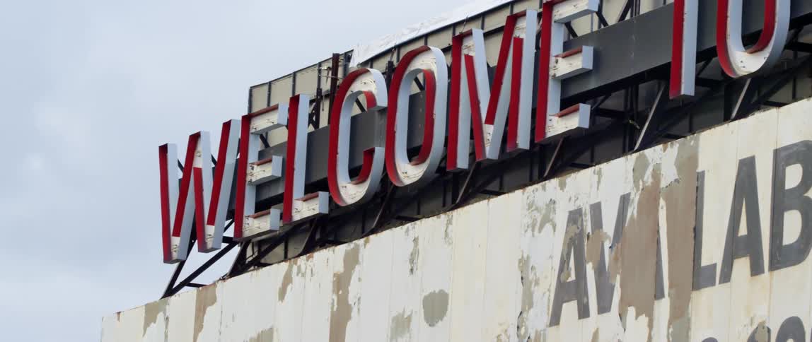 Welcome sign atop a structure in a billboard outdoors