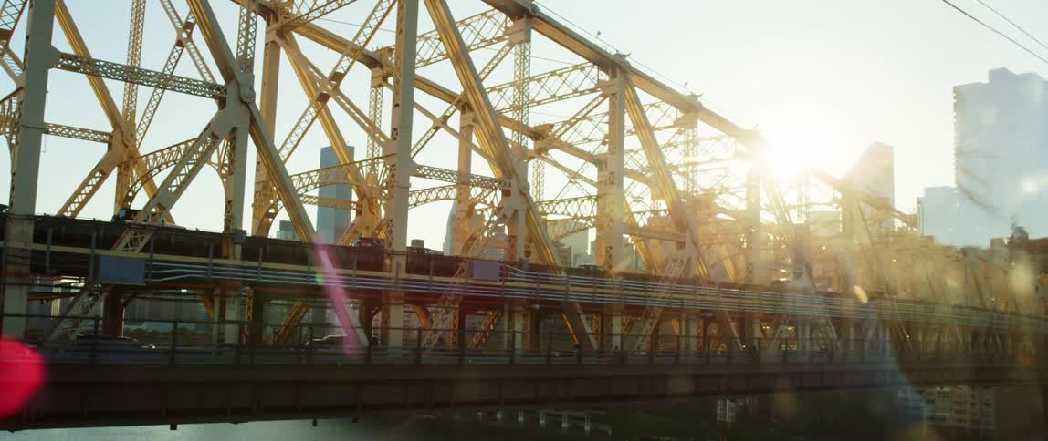 Traffic moves along a bridge in a metropolis before sunset