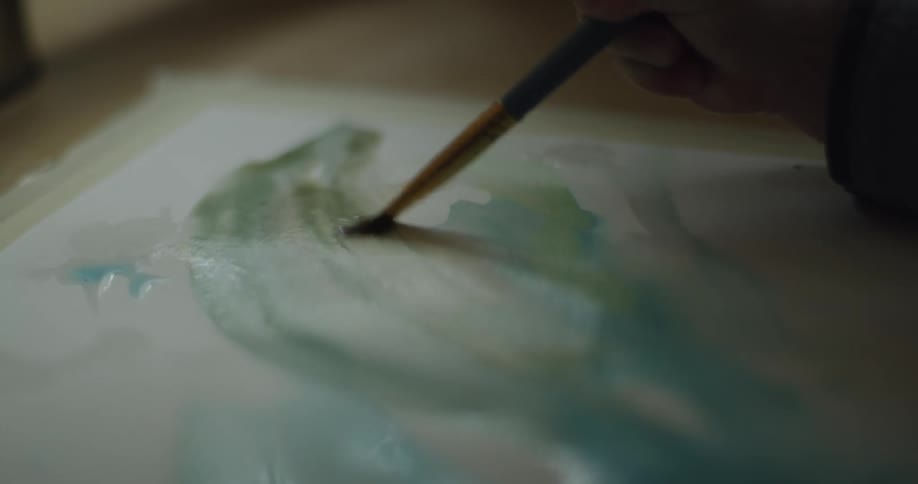 A child painting with watercolors on a piece of paper