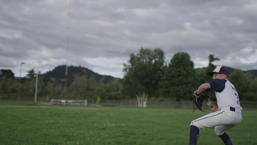 A child catches a baseball and throws it