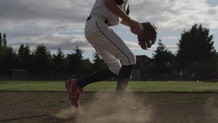 A child runs to catch a baseball and throws it to another player