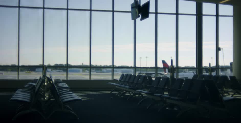 Airplane shows on tarmac showing through windows next to empty waiting area