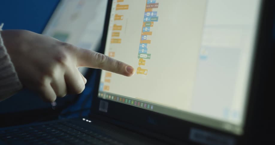 A woman points at the screen on a laptop