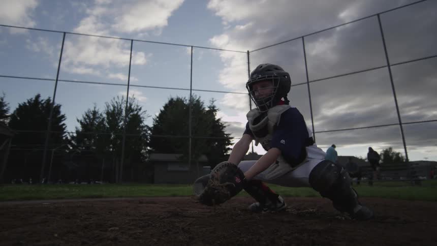 Youth catcher blocks baseball