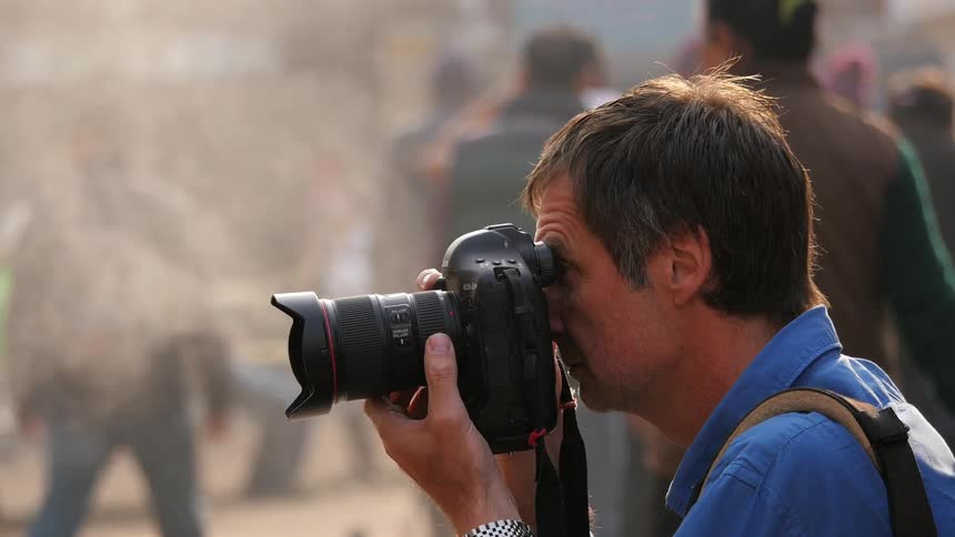 Man with camera photographing the people walking by