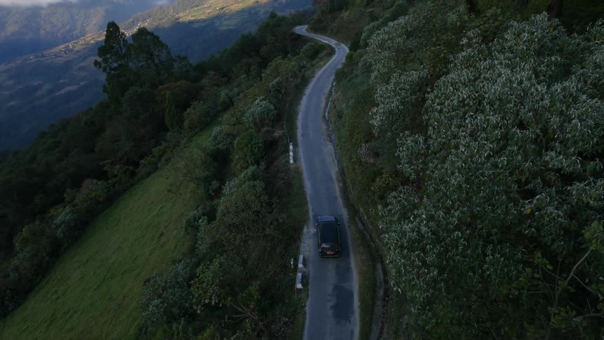 A vehicle moves down a mountain road
