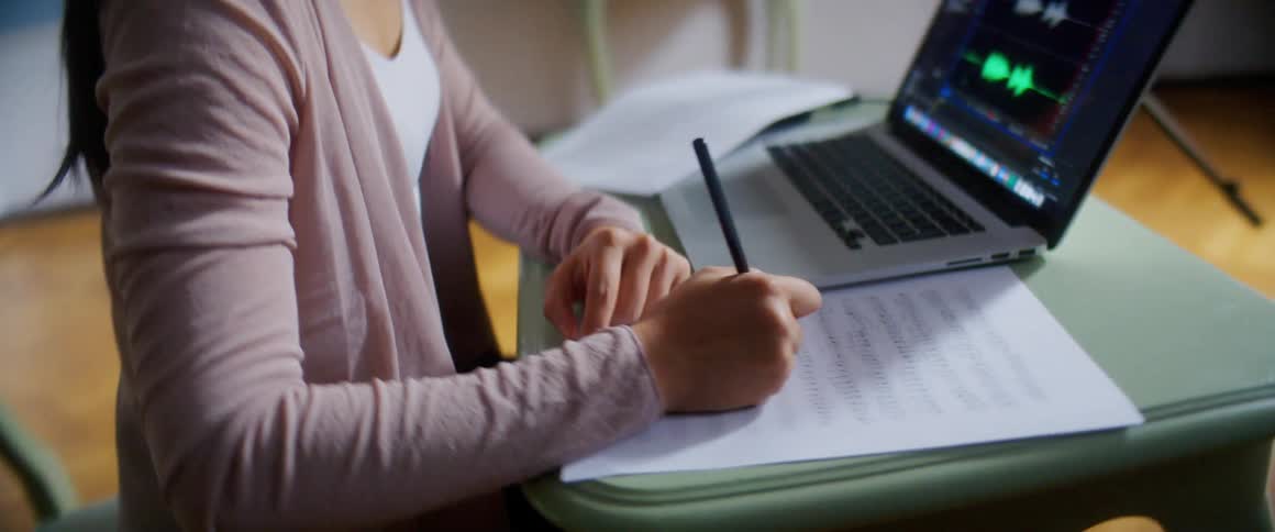 A woman is writing at a desk