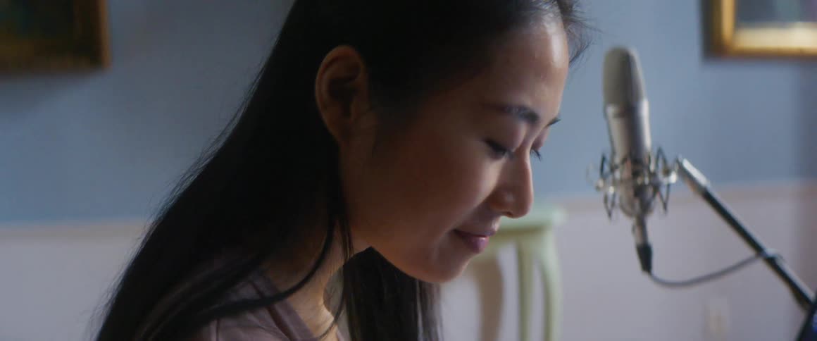 A woman is sitting inside a room during the day