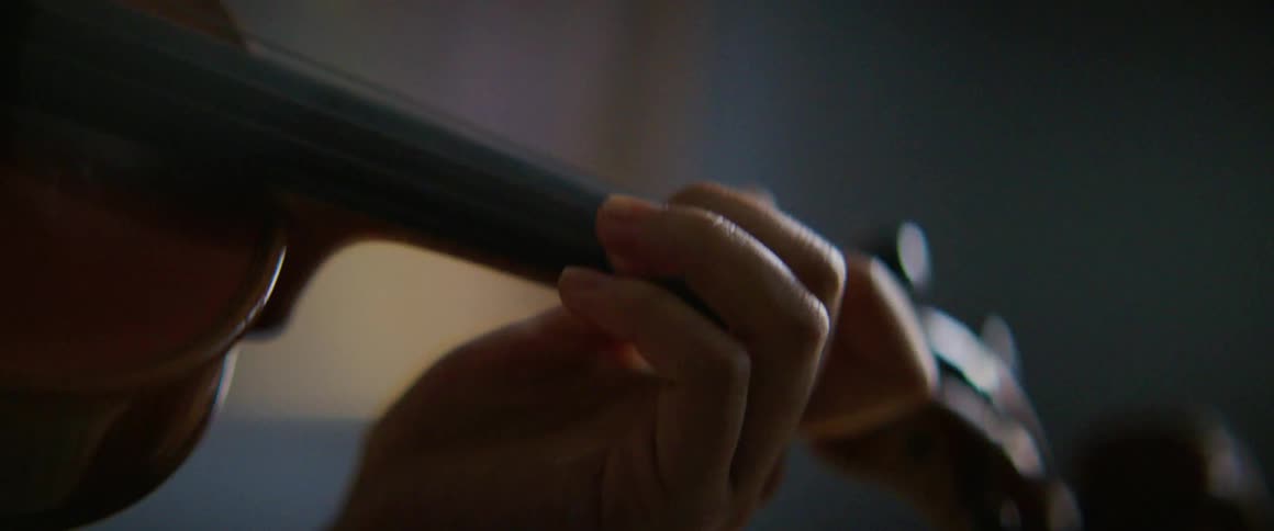 A person holding and playing a violin