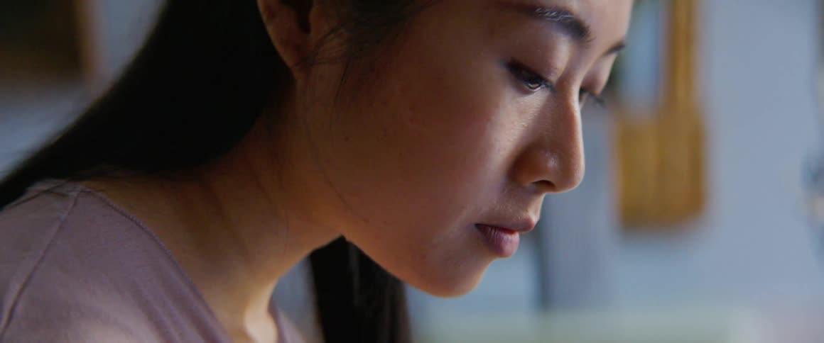 A woman is sitting indoors during the daytime