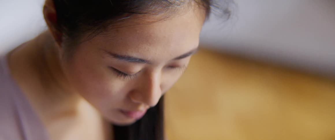 Woman face downward with closed eyes in wooden floored room