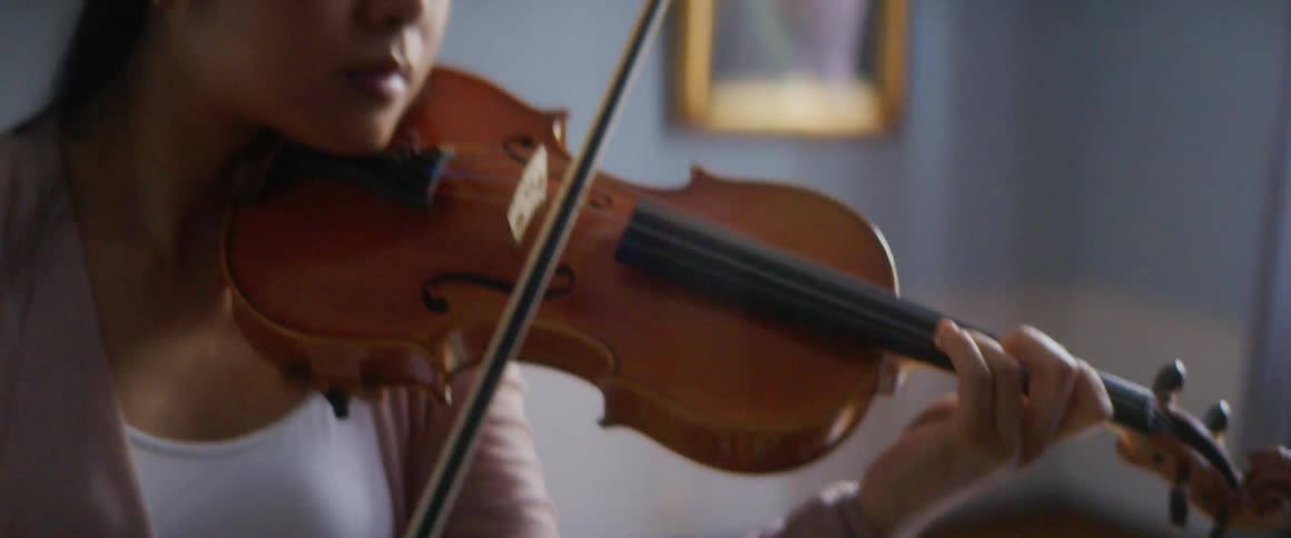 A woman is playing an instrument indoors during the day