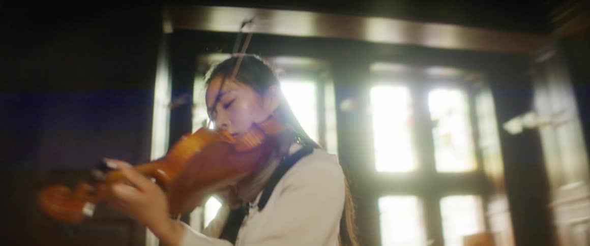 A woman plays the violin on a stage