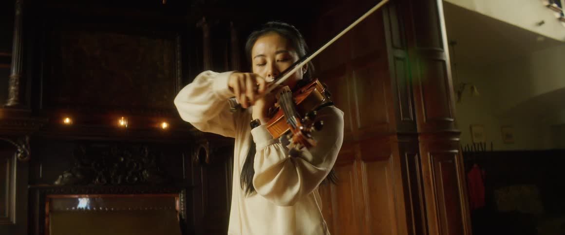 A woman playing a violin indoors