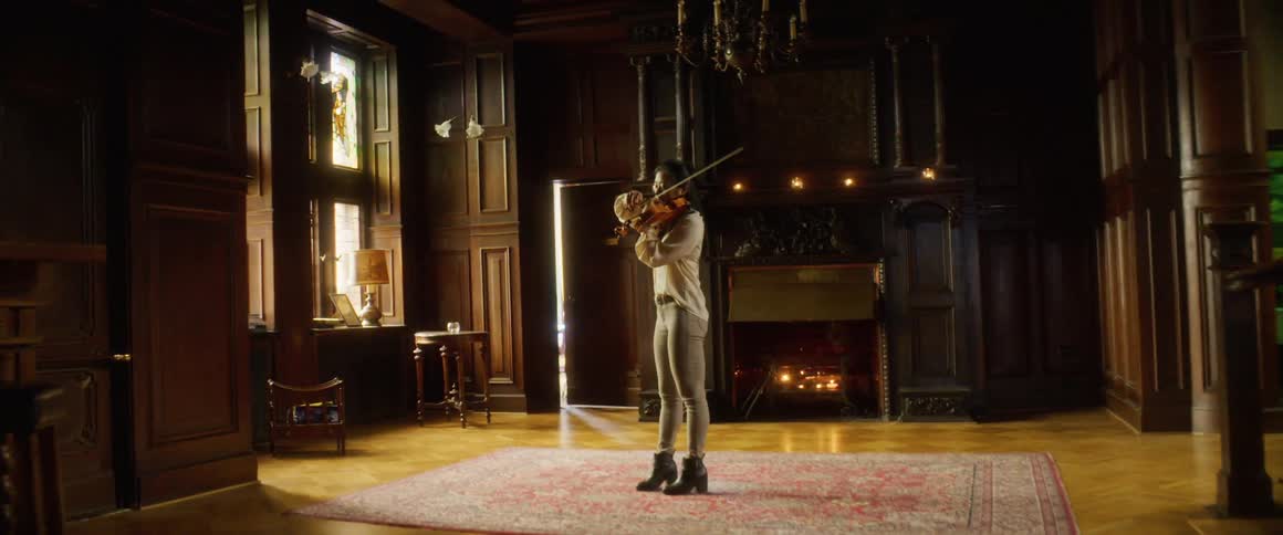 A woman is playing a music instrument in a room