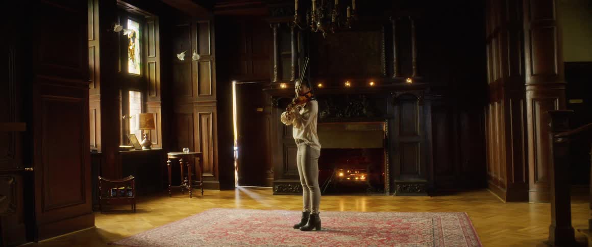 A woman playing the violin in a home