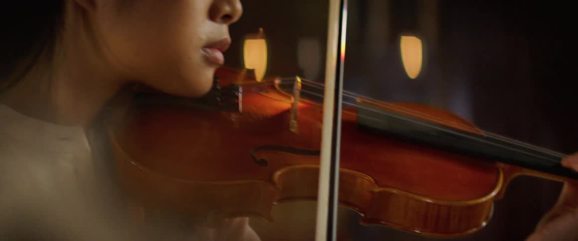 Woman in long sleeves plays violin
