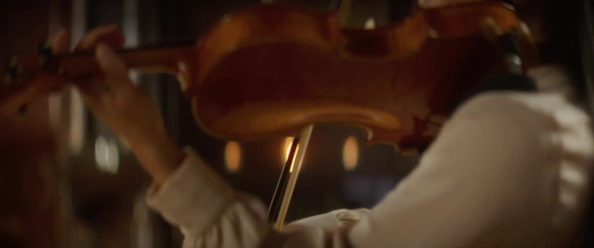 A woman in a room playing a violin