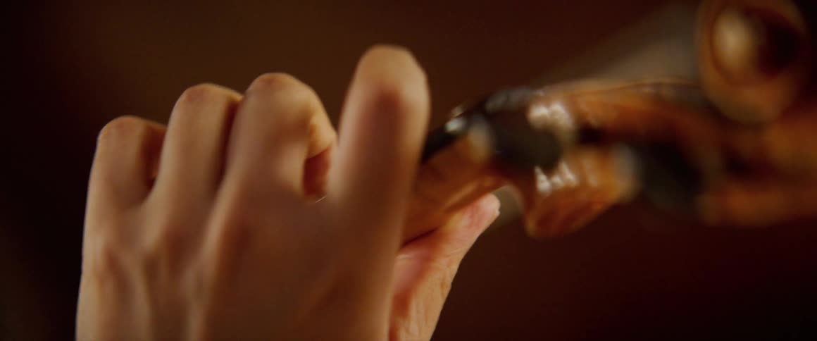 Close up of a womans hand as she plays a violin