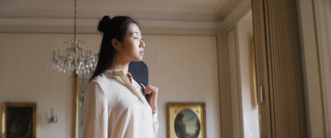 A young woman gazes out of her window