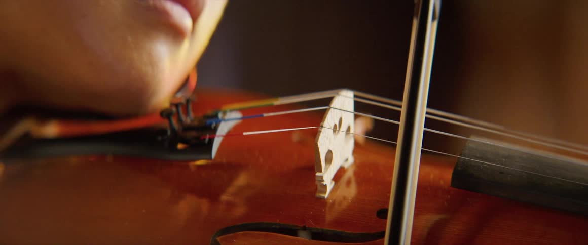A woman is playing a violin indoors