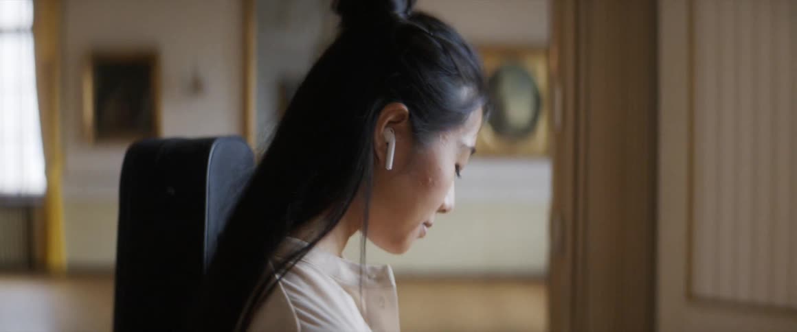 A young musician sways along to music shes listening to on her smart phone
