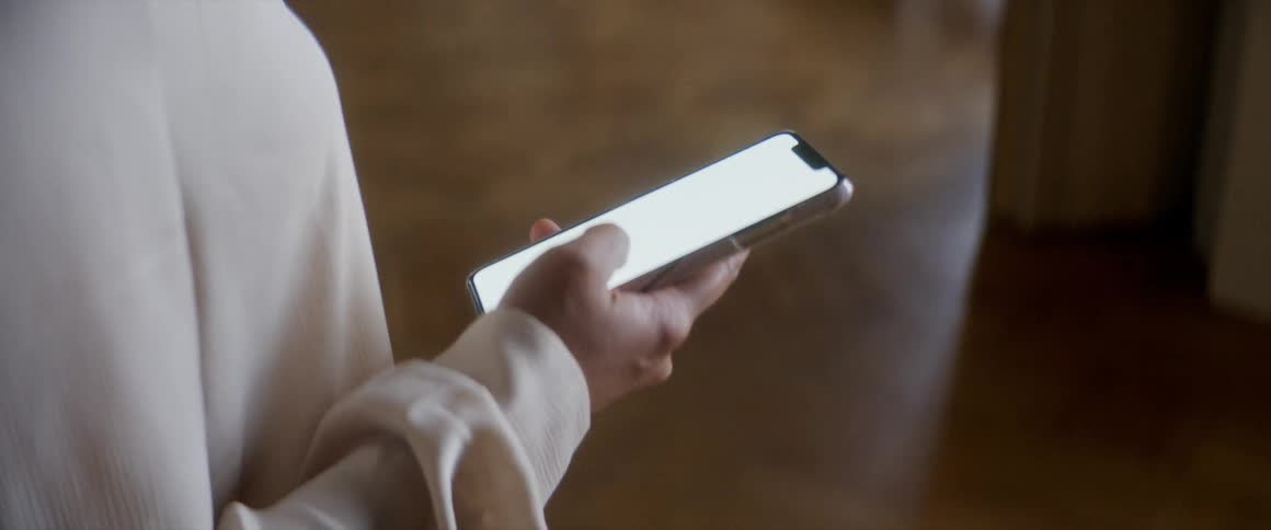 A person in a room looking at a smart phone