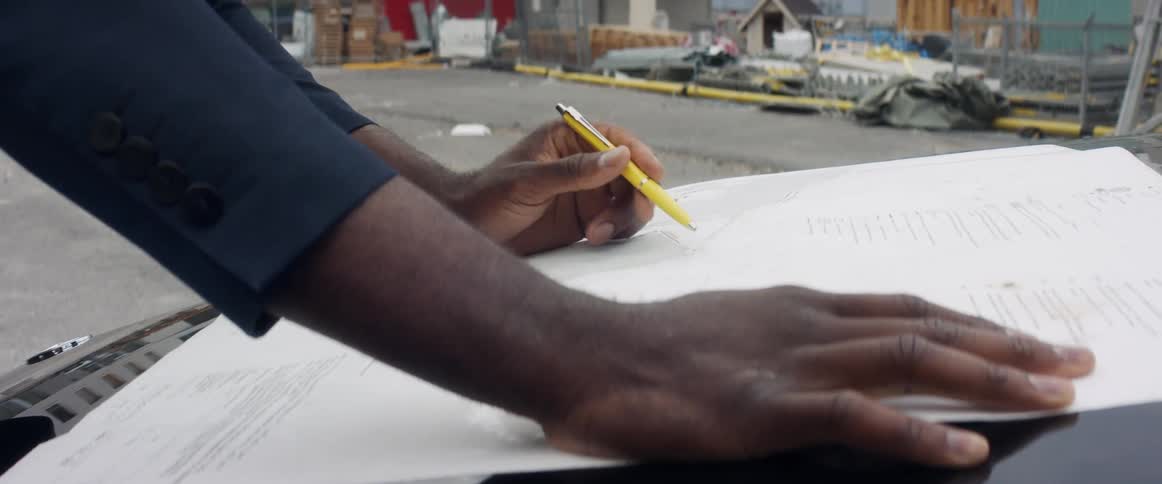 A man looks at paperwork at a construction site