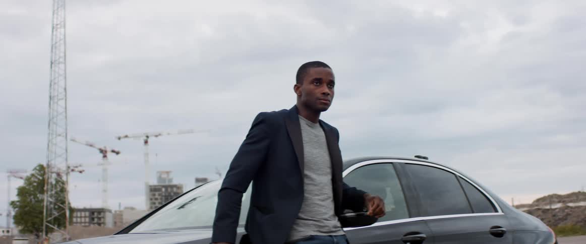 A man is standing by his vehicle outdoors in spring