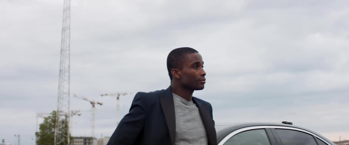 A man is standing outdoors by his car