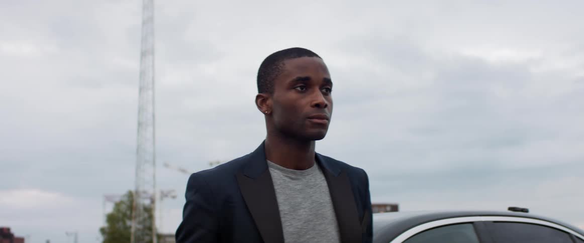 A man is standing by his car outdoors in spring