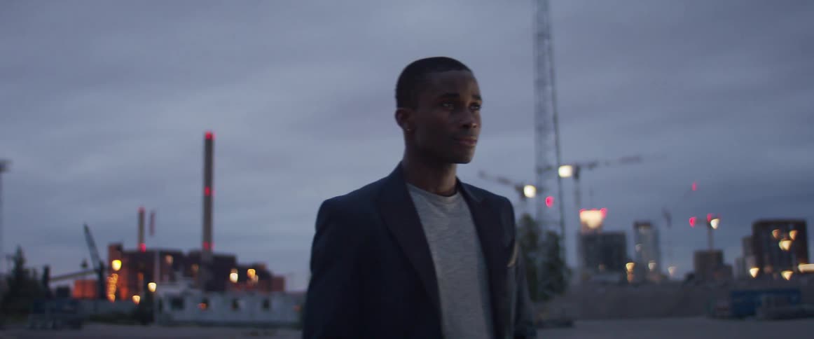 A man is standing outdoors in a city