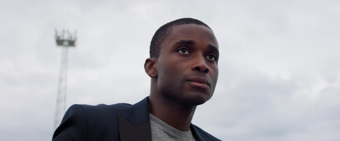 A man is standing outdoors during the day