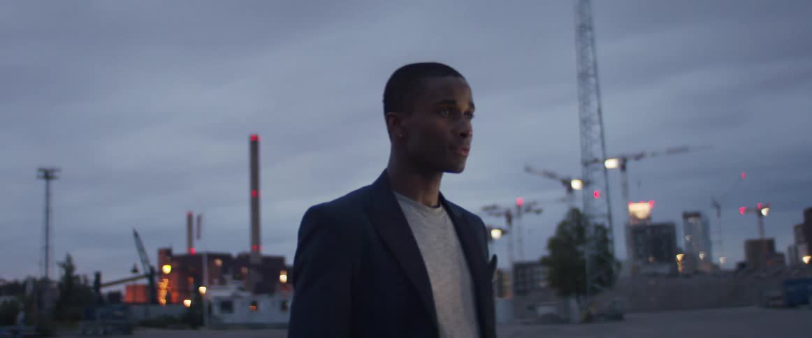 A man is standing in a downtown city