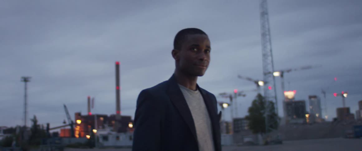 A man is standing under a cloudy sky
