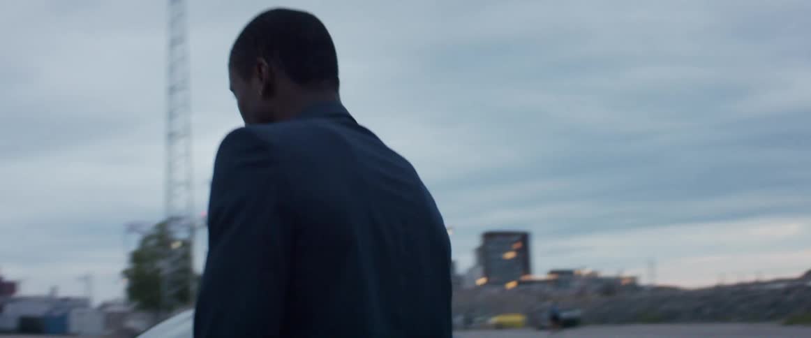 A man is walking outdoors in a downtown city