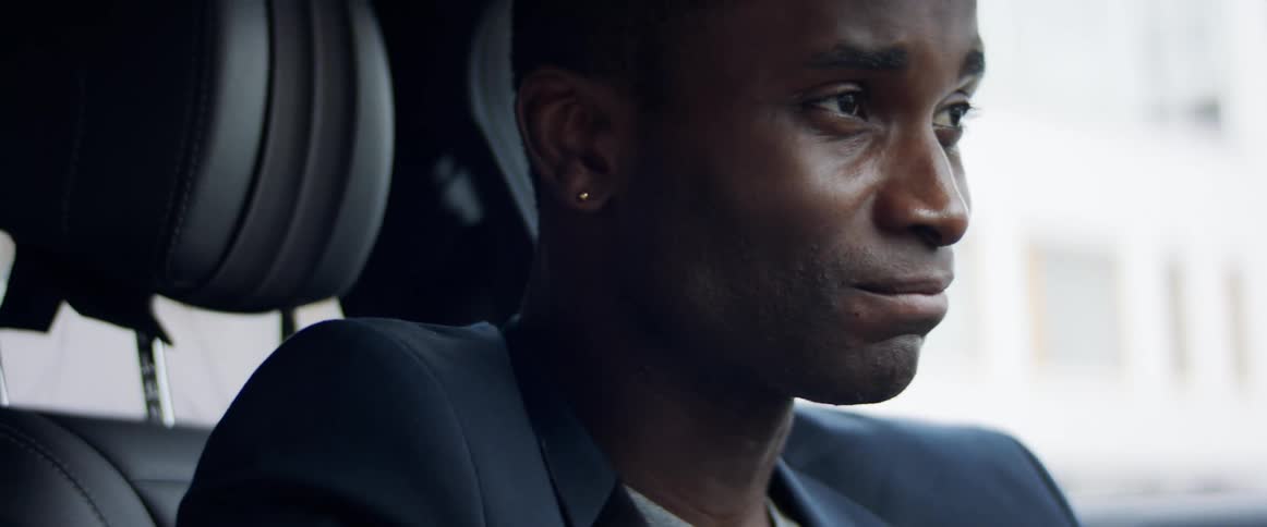 A man is sitting in his car during the day
