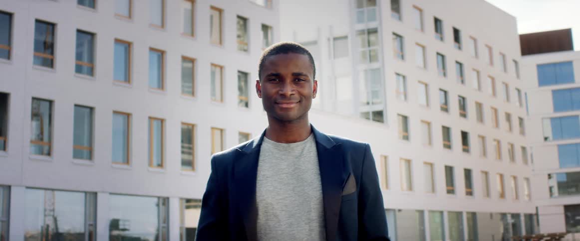 A man is standing outdoors in a city