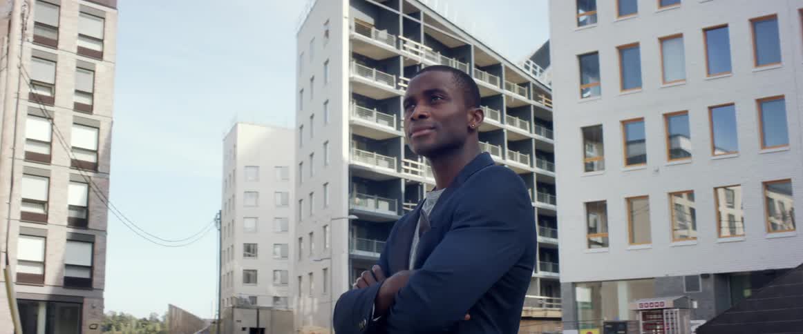 A man is standing in a downtown city