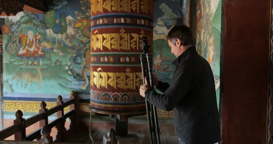 Man setting up a camera tripod in a temple