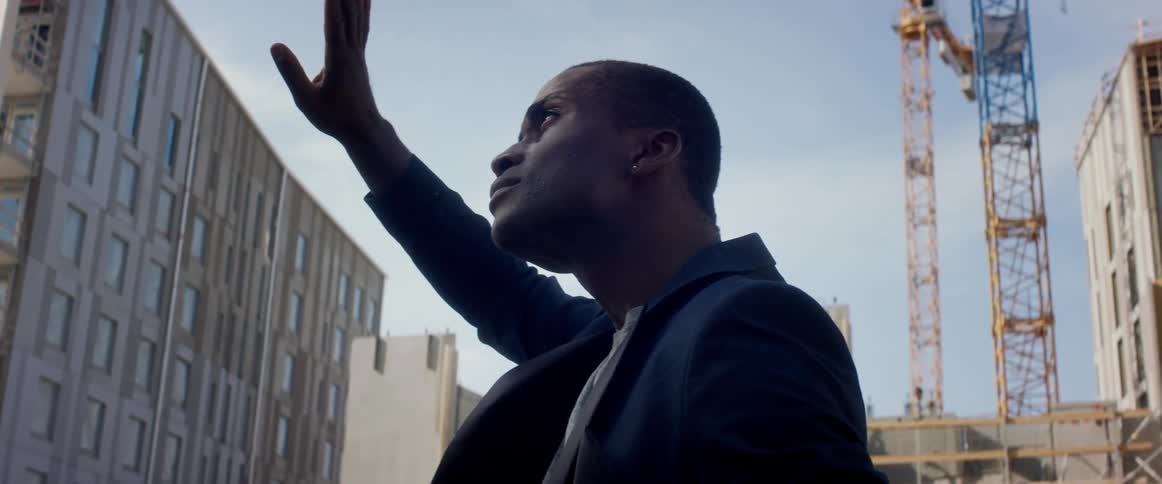 A man is standing in a city during the day