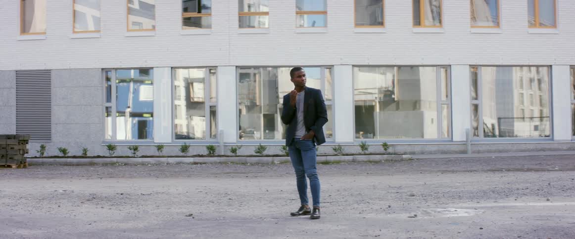 A man poses outdoors in a city during the day