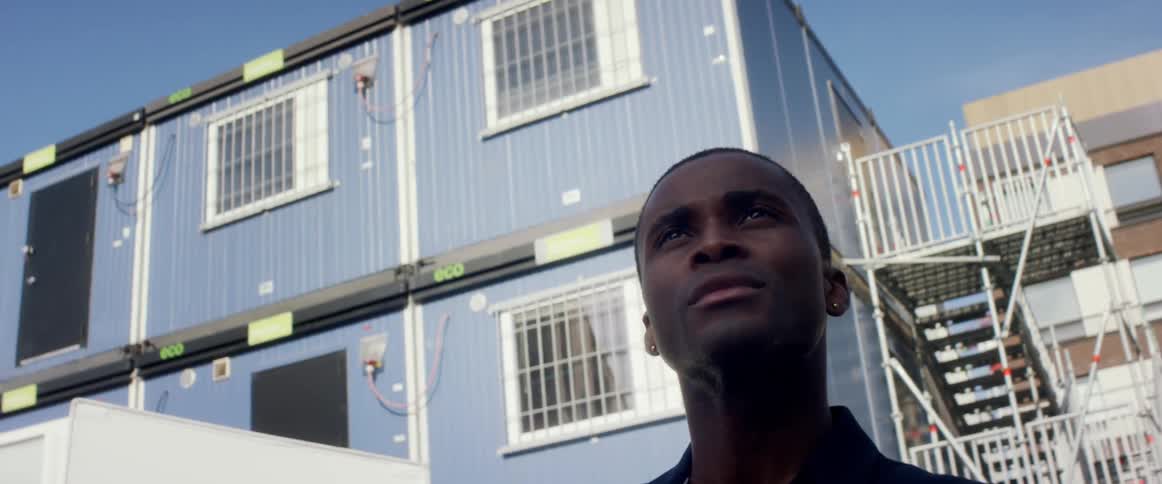 A man is standing in a city during the day