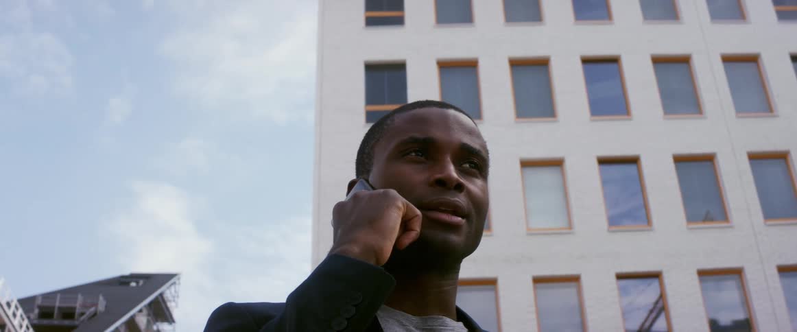 A man is talking on his cellphone in a downtown city